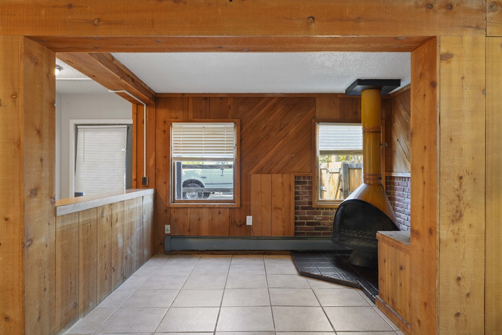 A room with wooden walls and a black oven.
