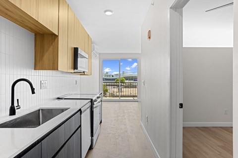 A kitchen with a black sink and white countertops.
