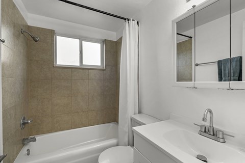 A bathroom with a white tub and sink.