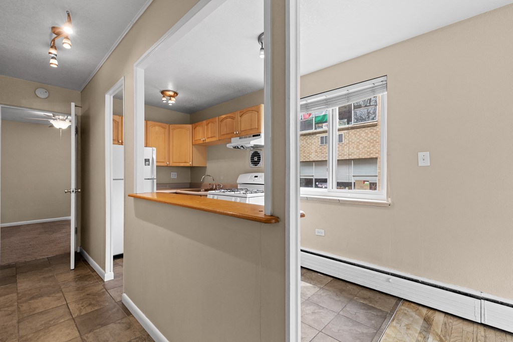 the view of a kitchen from the living room with the door open