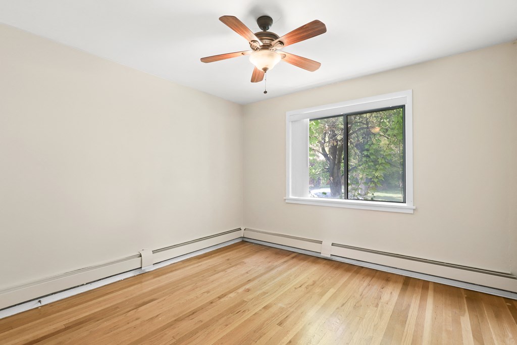 an empty room with a window and a ceiling fan