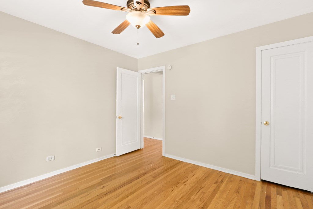 a living room with wood floors and a ceiling fan
