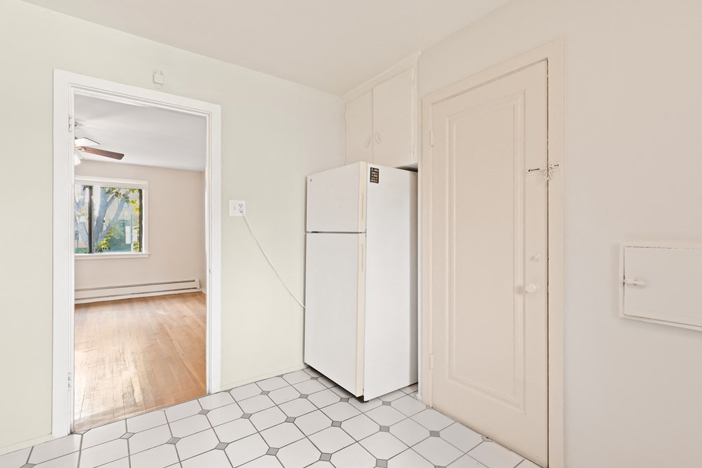 an empty room with a refrigerator in the middle of it