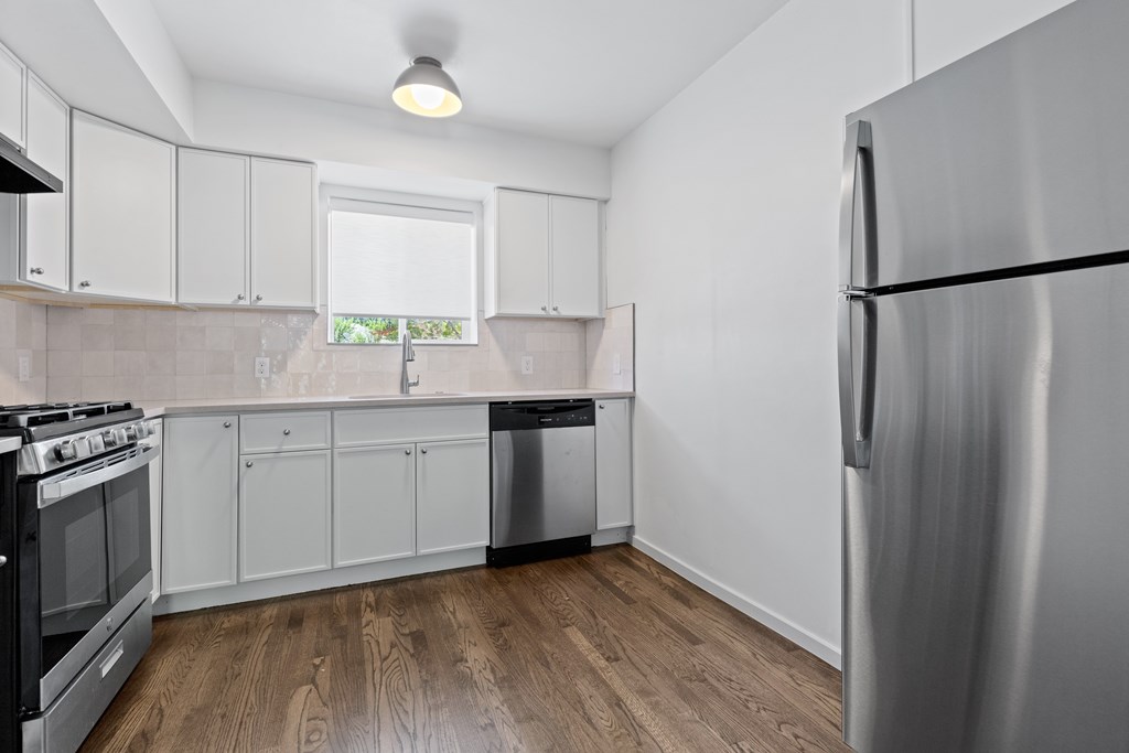 a kitchen with white cabinets and stainless steel appliances