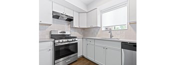 A kitchen with white cabinets and a stainless steel oven.