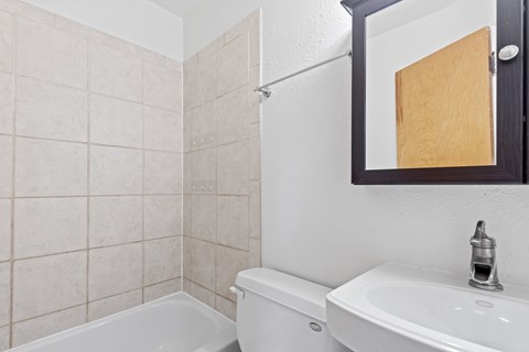 A white toilet sits next to a white sink in a bathroom.