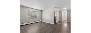 A room with wooden floors and a painting on the wall.
