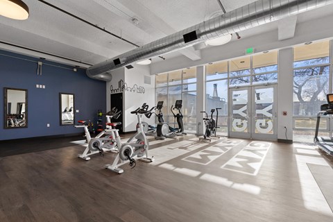 A gym with exercise bikes and a mirror on the wall.