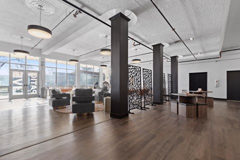 A modern office space with wooden floors and black columns.