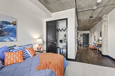 A bedroom with a bed, a chair, and a painting on the wall.