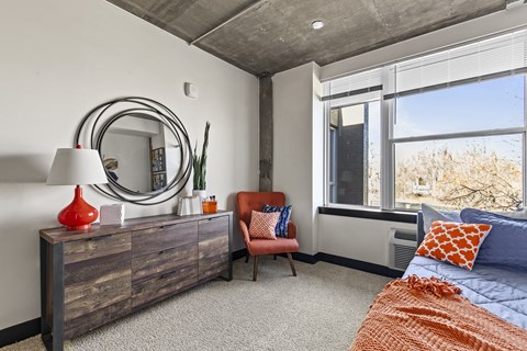 A bedroom with a large bed and a chair.