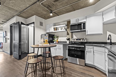 A kitchen with a table and chairs in the middle of it.