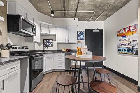A kitchen with a round table and chairs in the middle.