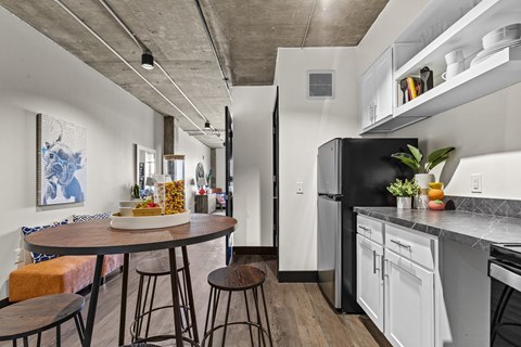 A kitchen with a table and chairs and a refrigerator.