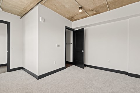A room with a black door and a carpet on the floor.