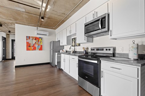 A kitchen with white cabinets and stainless steel appliances.