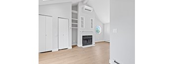 an empty living room with a fireplace and white walls