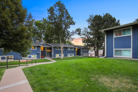 A blue building with a green lawn in front.