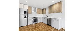 a renovated kitchen with white cabinets and stainless steel appliances