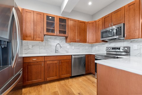 A kitchen with wooden cabinets and a white counter.
