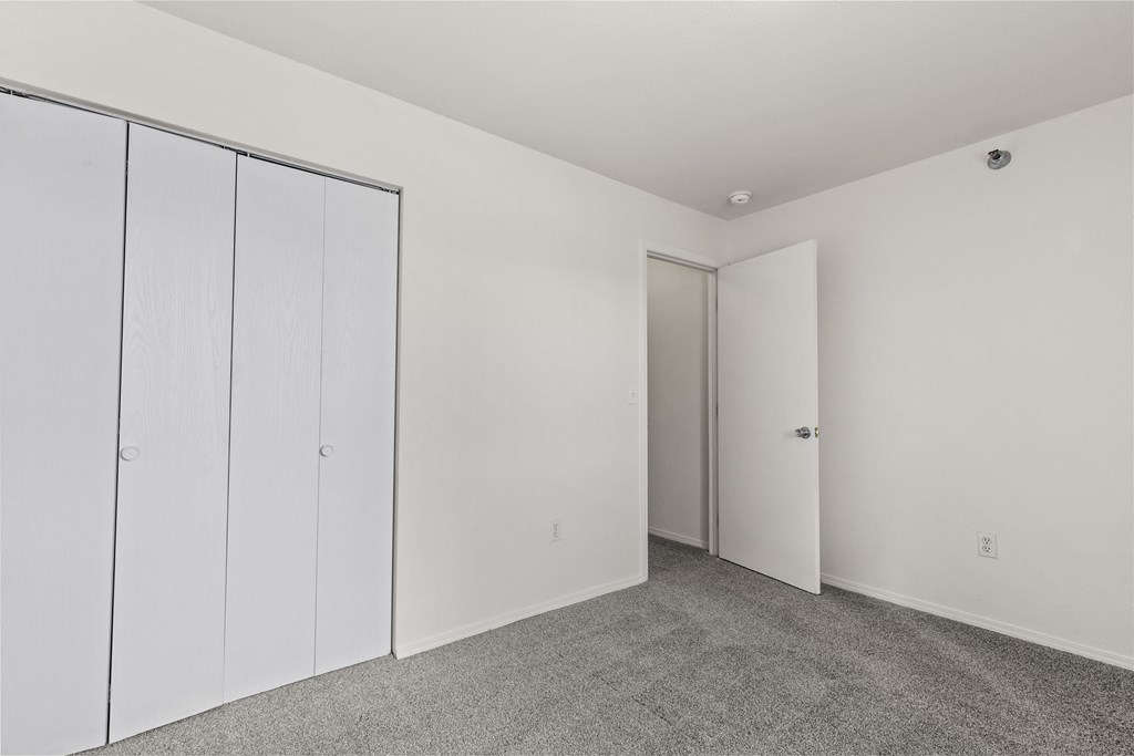 A room with a white door and three white cupboards.