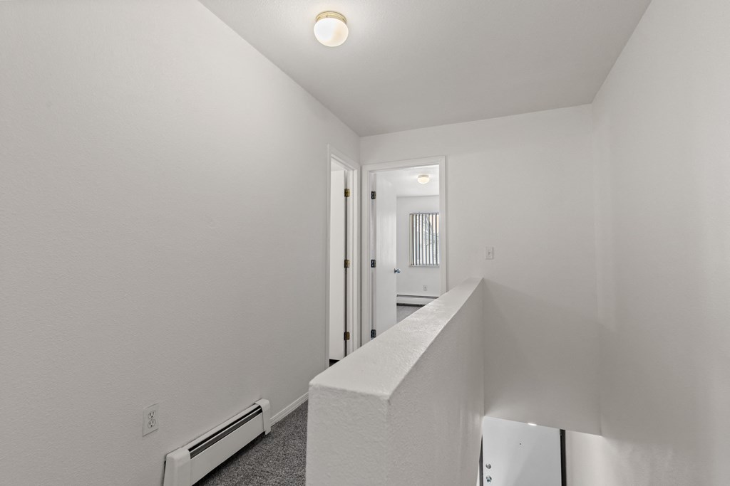 A white room with a doorway leading to another room.