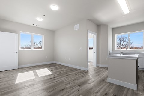 A spacious room with wooden floors and white walls.