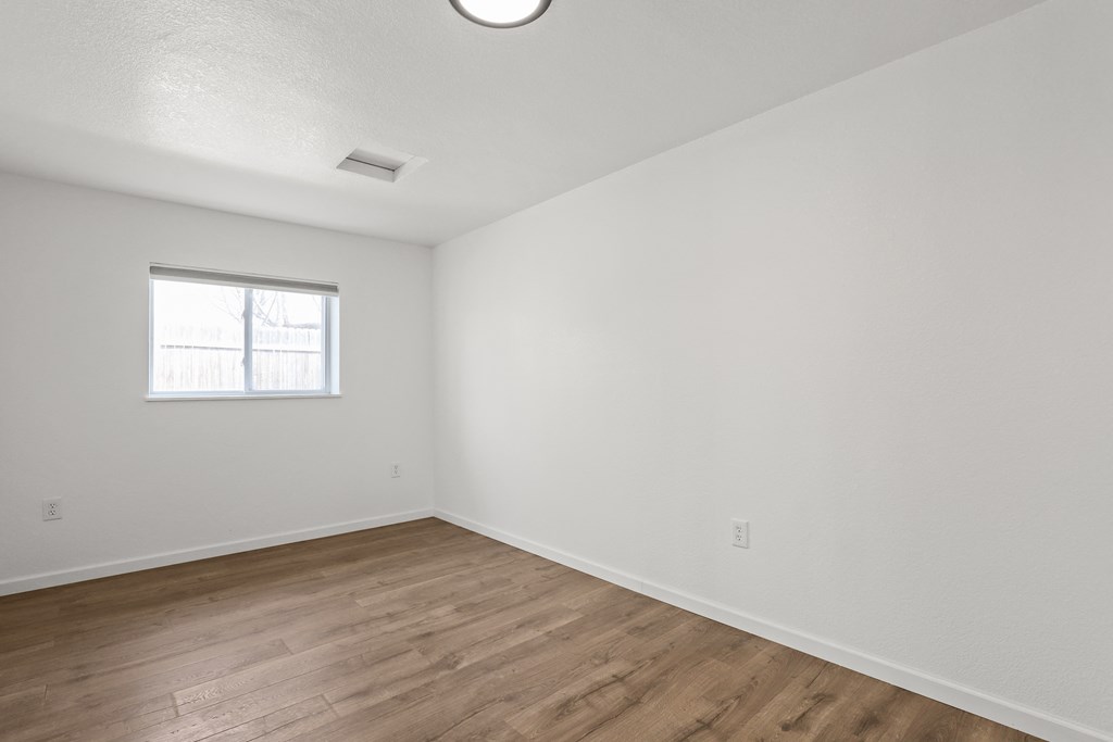 an empty room with white walls and a window