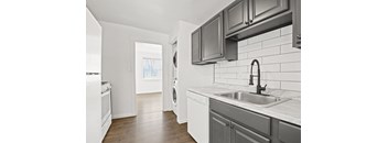 an empty kitchen with a sink and a washer and dryer