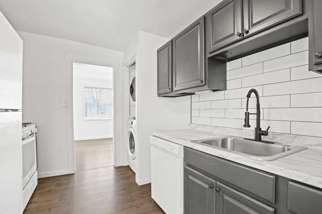 an empty kitchen with a sink and a washer and dryer