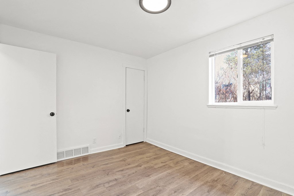 an empty room with white walls and a window