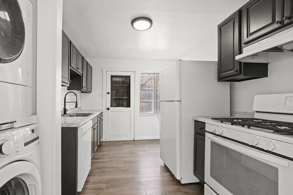 a kitchen with white appliances and black and white cabinets