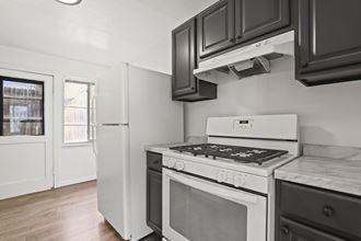 a kitchen with white appliances and black cabinets and a refrigerator