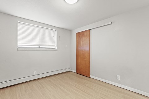 the living room of an apartment with a door and a window
