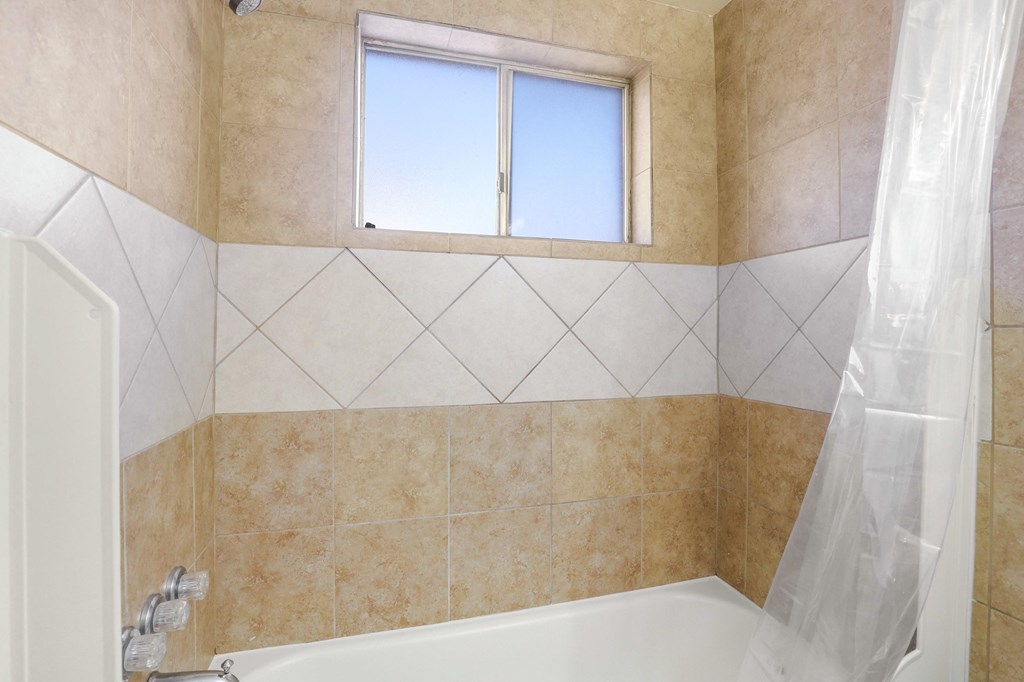 a bathroom with a tub and a window and a shower curtain