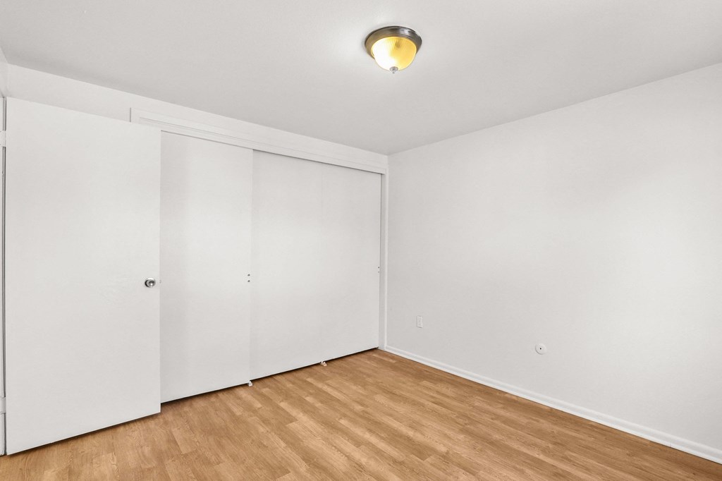 an empty room with white walls and a wood floor