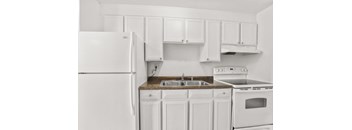 a kitchen with white cabinets and a sink and a refrigerator