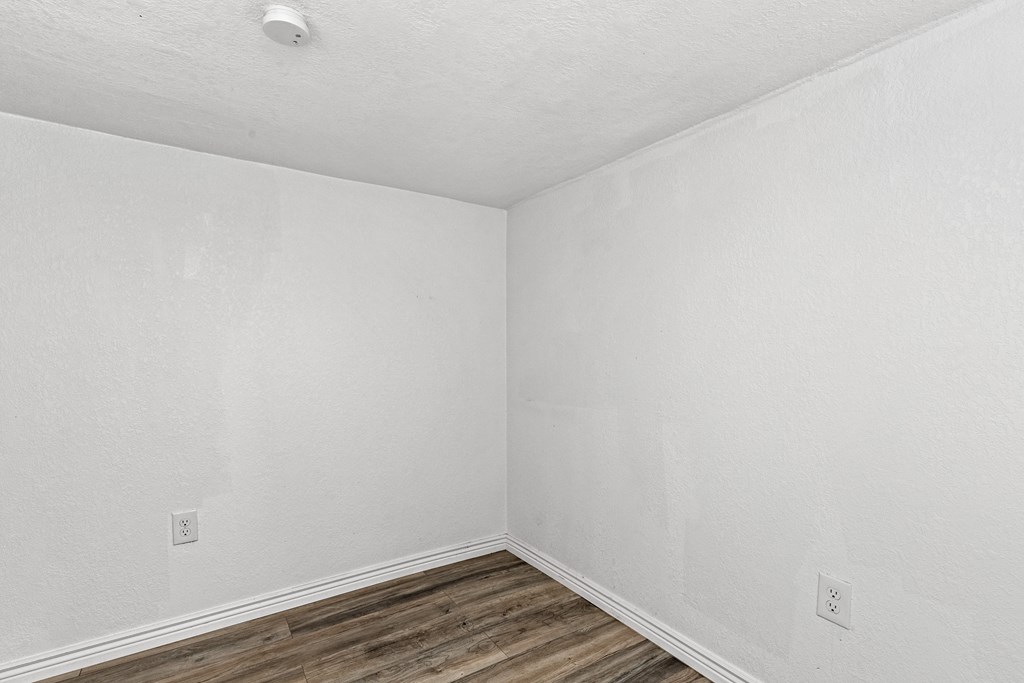 an empty room with white walls and wooden floors