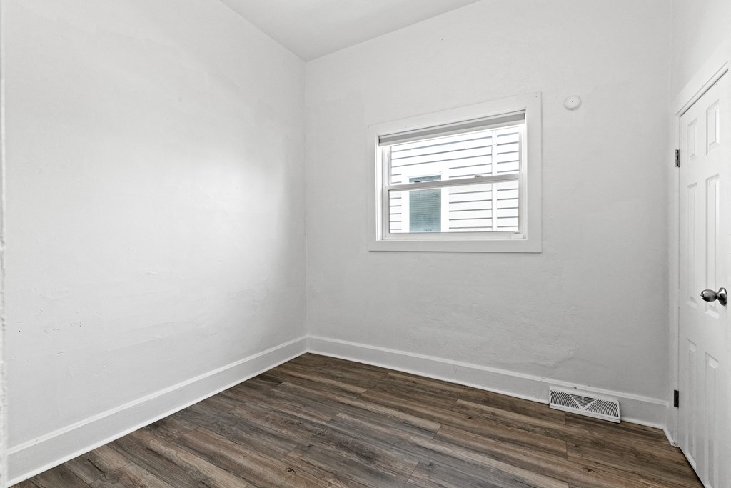 an empty room with white walls and a window