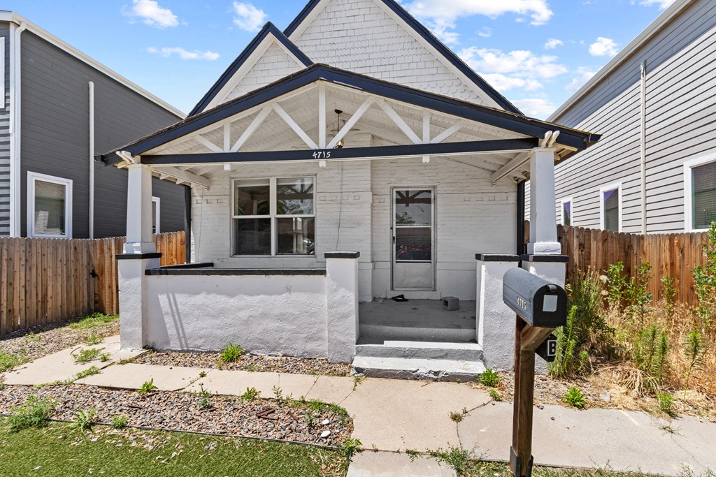 the front of a white house with a porch and a parking meter