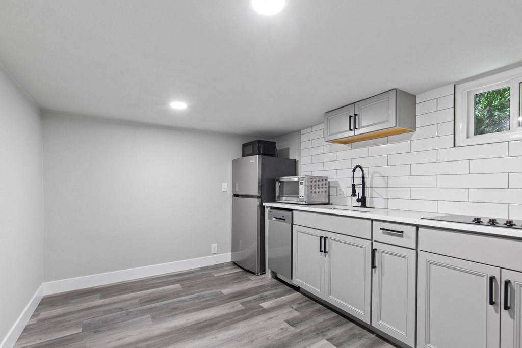 a kitchen with white cabinets and a stainless steel refrigerator