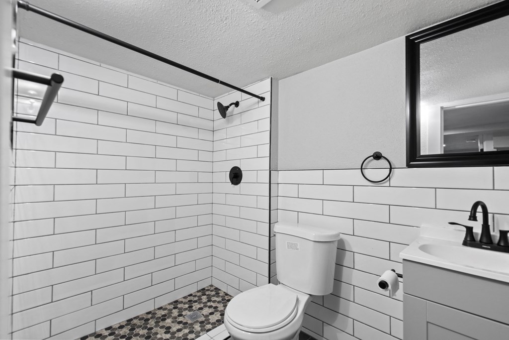 a bathroom with white tiled walls and a white toilet