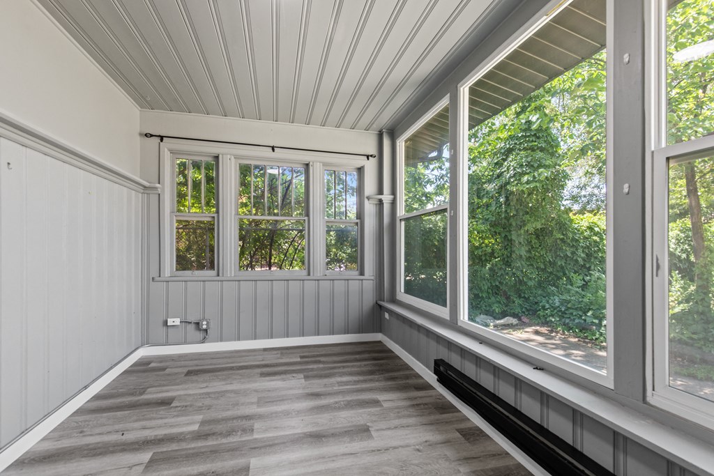 a sun room with large windows and a bench