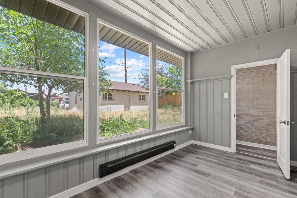 a living room with large windows and a door to a yard