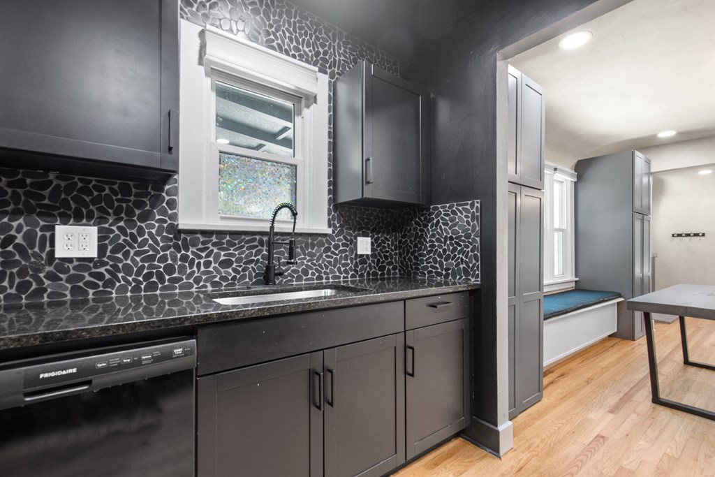 a kitchen with gray cabinets and a sink and a window
