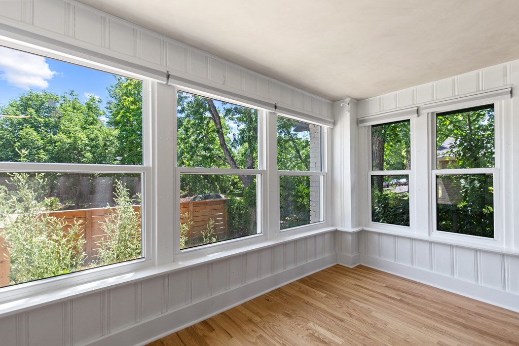 a living room with many windows and a wooden floor