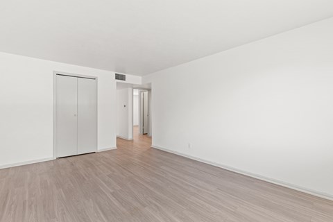 an empty living room with white walls and wood flooring