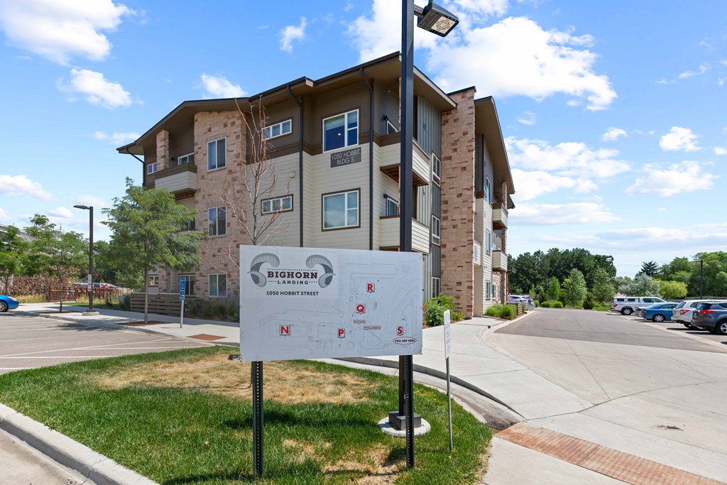 an apartment building with a sign in front of it