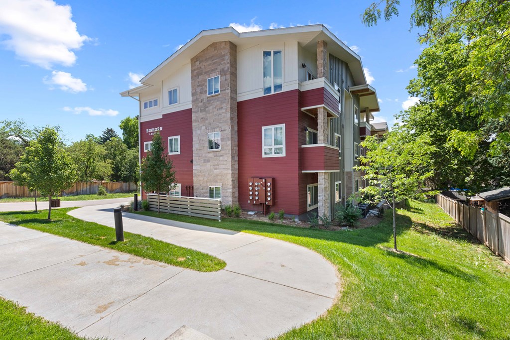 an apartment building with a sidewalk in front of it