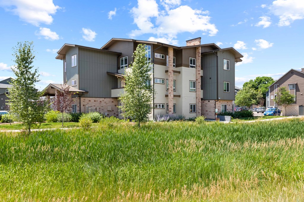 an apartment building with green grass in front of it